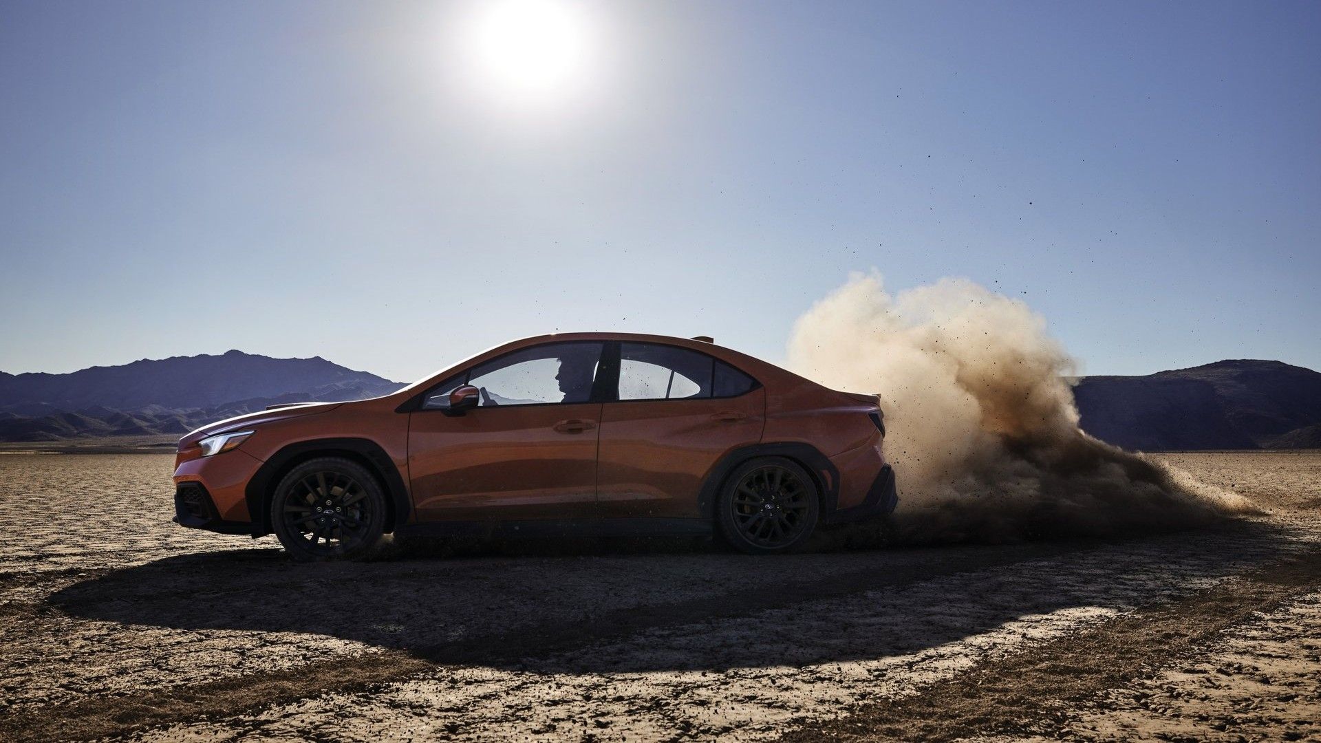 Side profile action shot of a 2022 Subaru WRX kicking up dirt