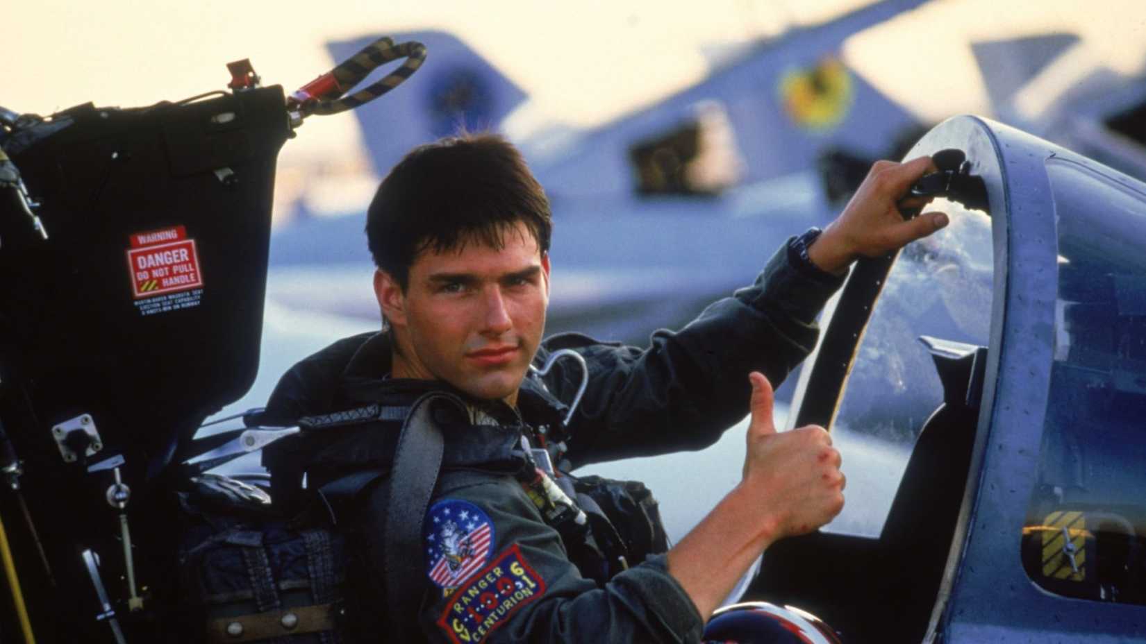Tom Cruise puts his thumb up.
