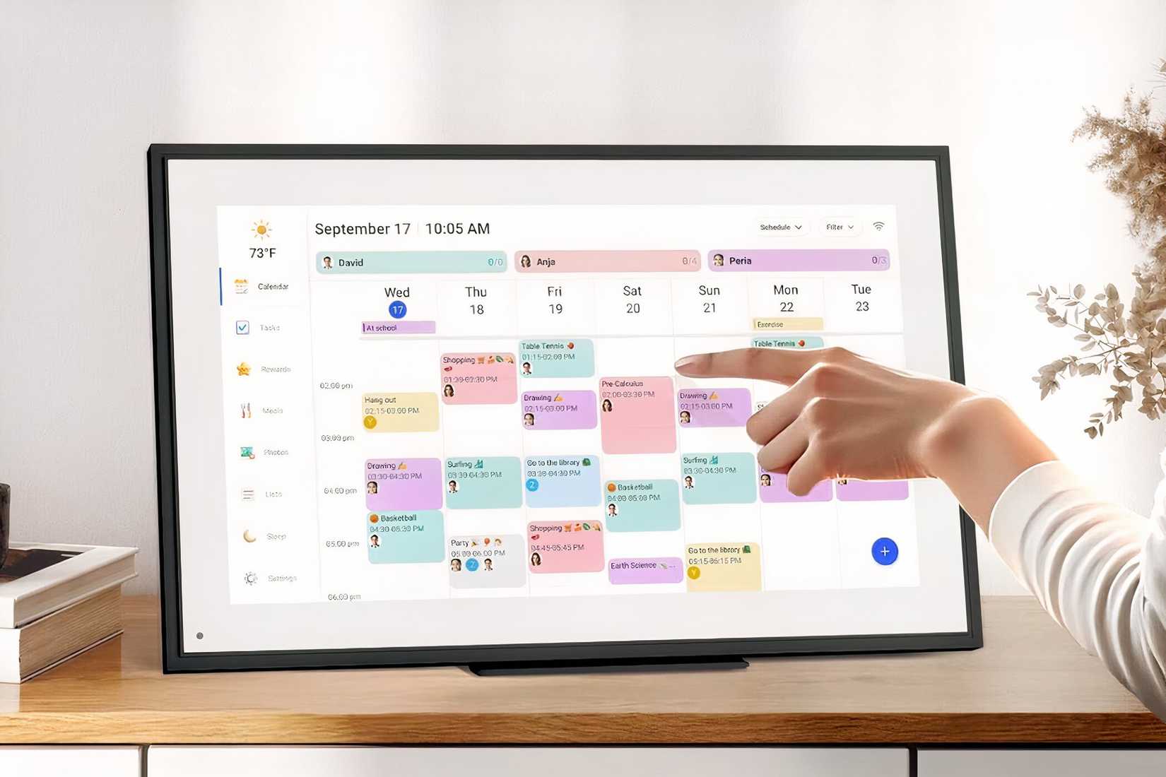 A woman using the LiviNGPAi Wall Planner Digital Calendar