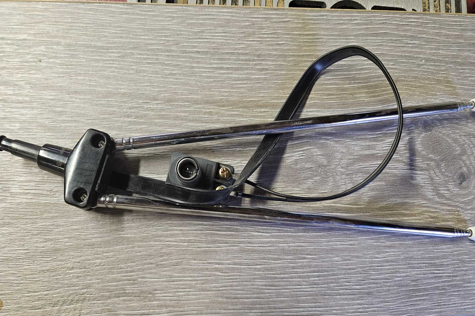 A pair of rabbit ears with a coaxial adapter on a gray table.