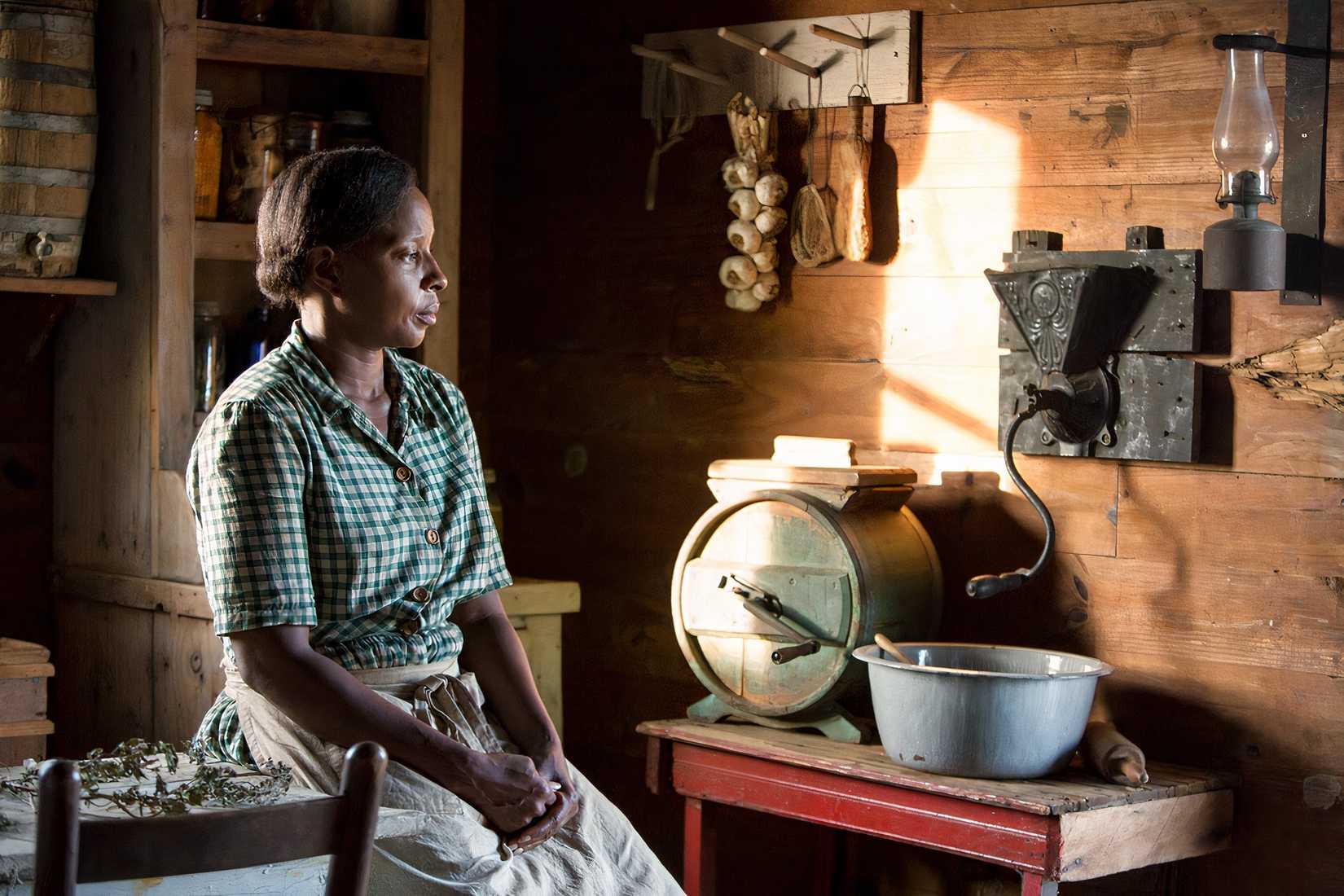 A woman sits down in Mudbound.