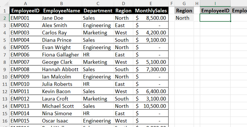 An Excel worksheet containing a data grid of employee records alongside a region cell and an empty destination cell for an output range.