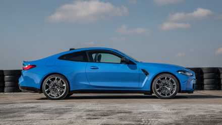 ブルーの 2022 BMW M4 Competition Coupe xDrive の静的な横顔画像。
