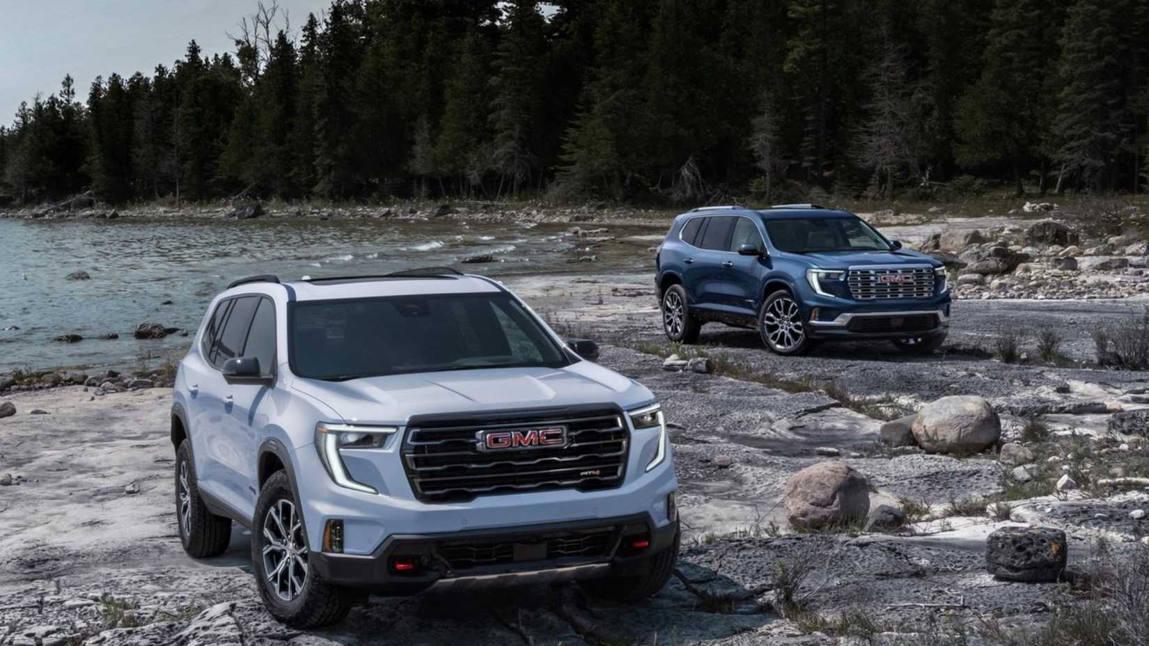 Static front 3/4 shot of white and blue 2024 GMC Acadias.