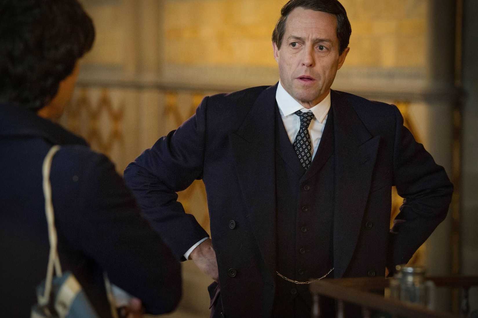 Hugh Grant puts his hands on his hips in A Very English Scandal.