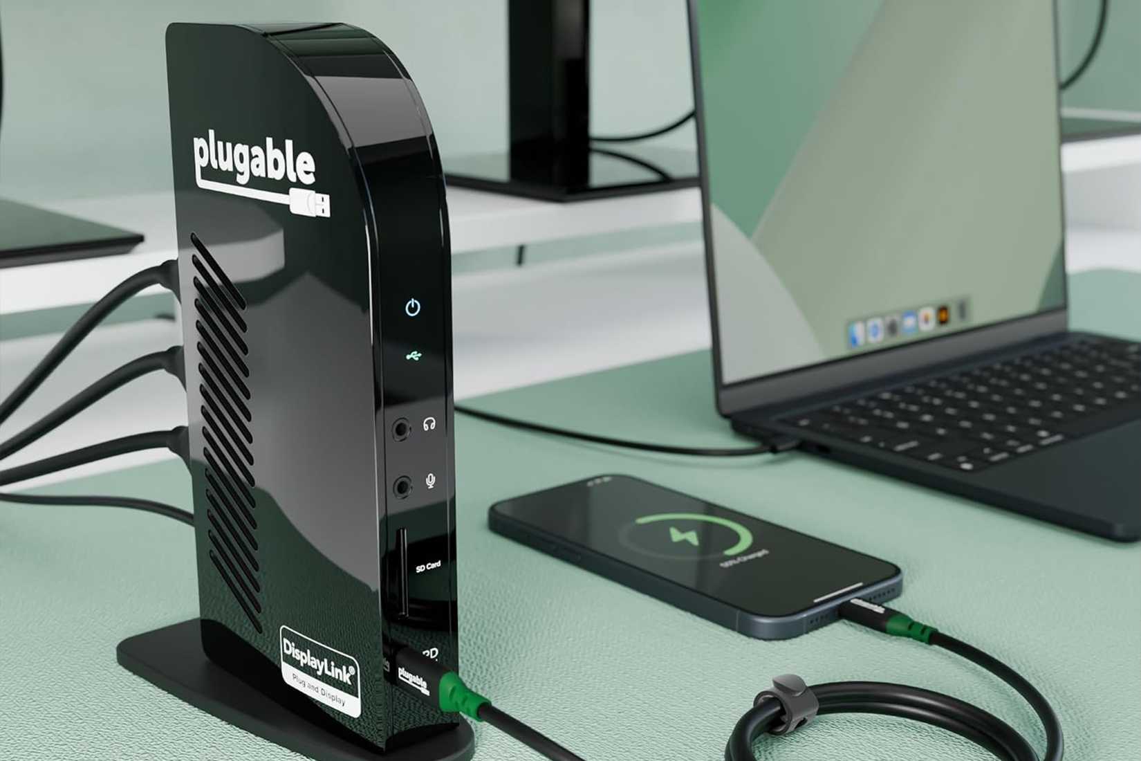 Plugable UD-ULTCDL docking station on a desk next to a laptop and phone.