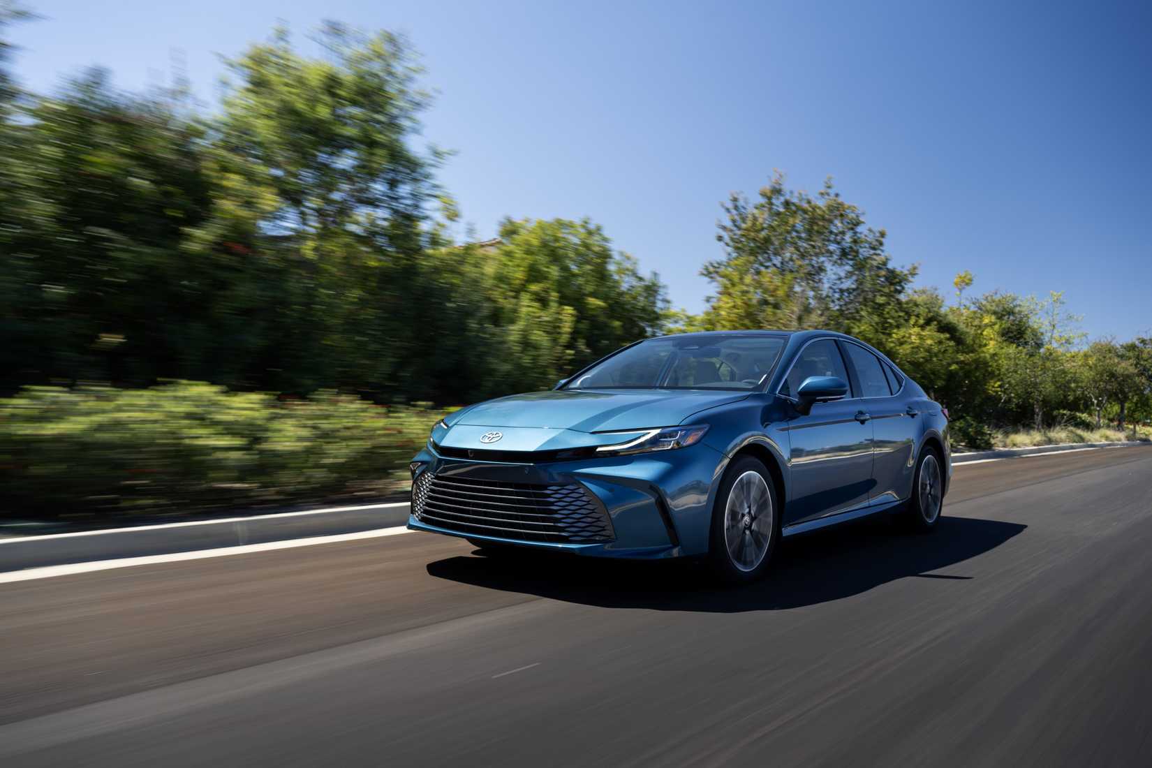 Dynamic front 3/4 shot of a blue 2026 Toyota Camry.