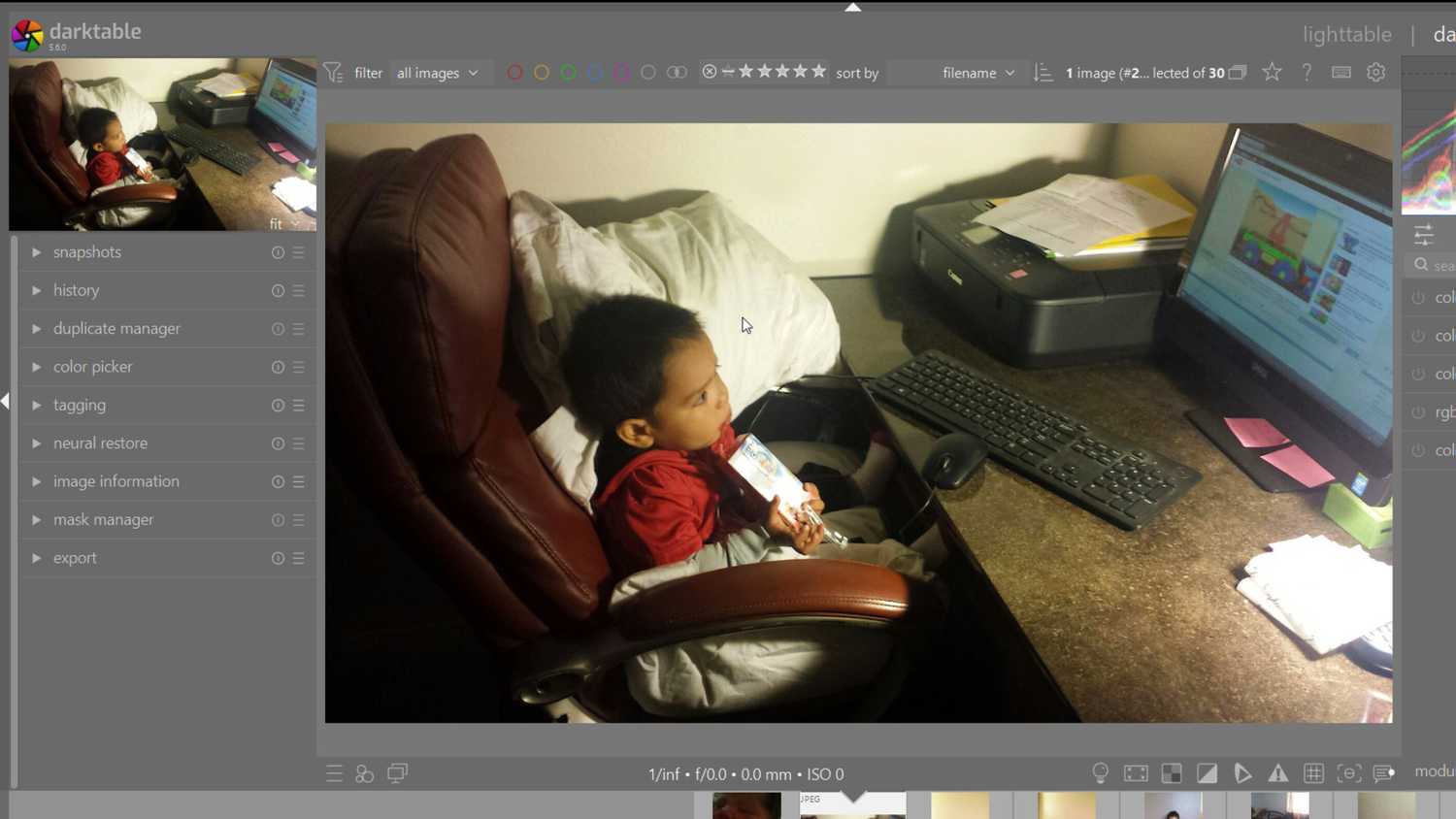 A child sitting and watching a computer in an image in darktable
