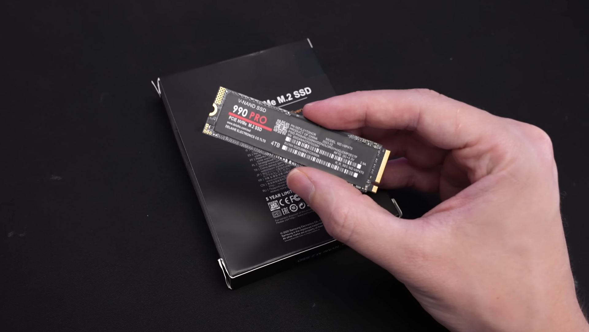 A person holding a counterfeit Samsung 990 Pro SSD.