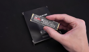 A person holding a counterfeit Samsung 990 Pro SSD.