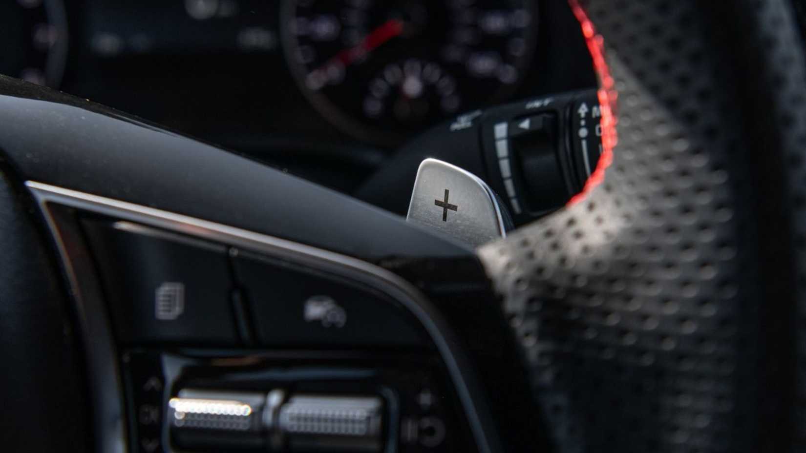 Close-up shot of the gear shift paddle behind the steering wheel of a 2022 Kia Forte.