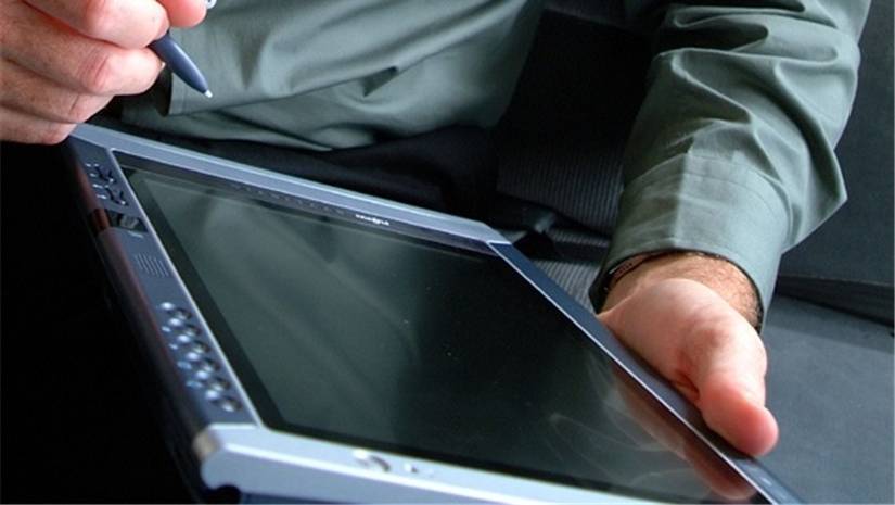 A man holding an early Windows tablet.