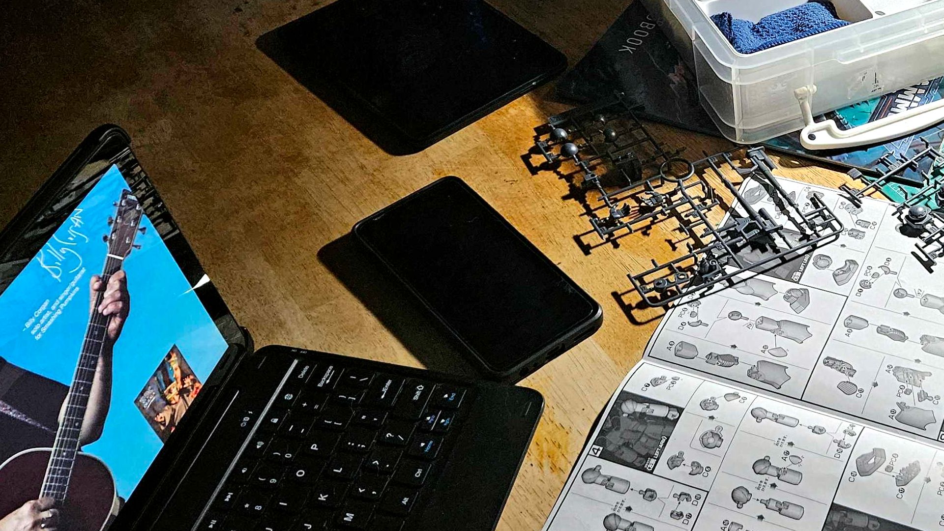 A phone lying on a table with a model kit