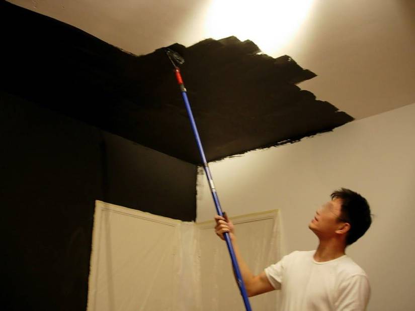 A man paints the ceiling with yShield Wi-Fi-blocking paint.