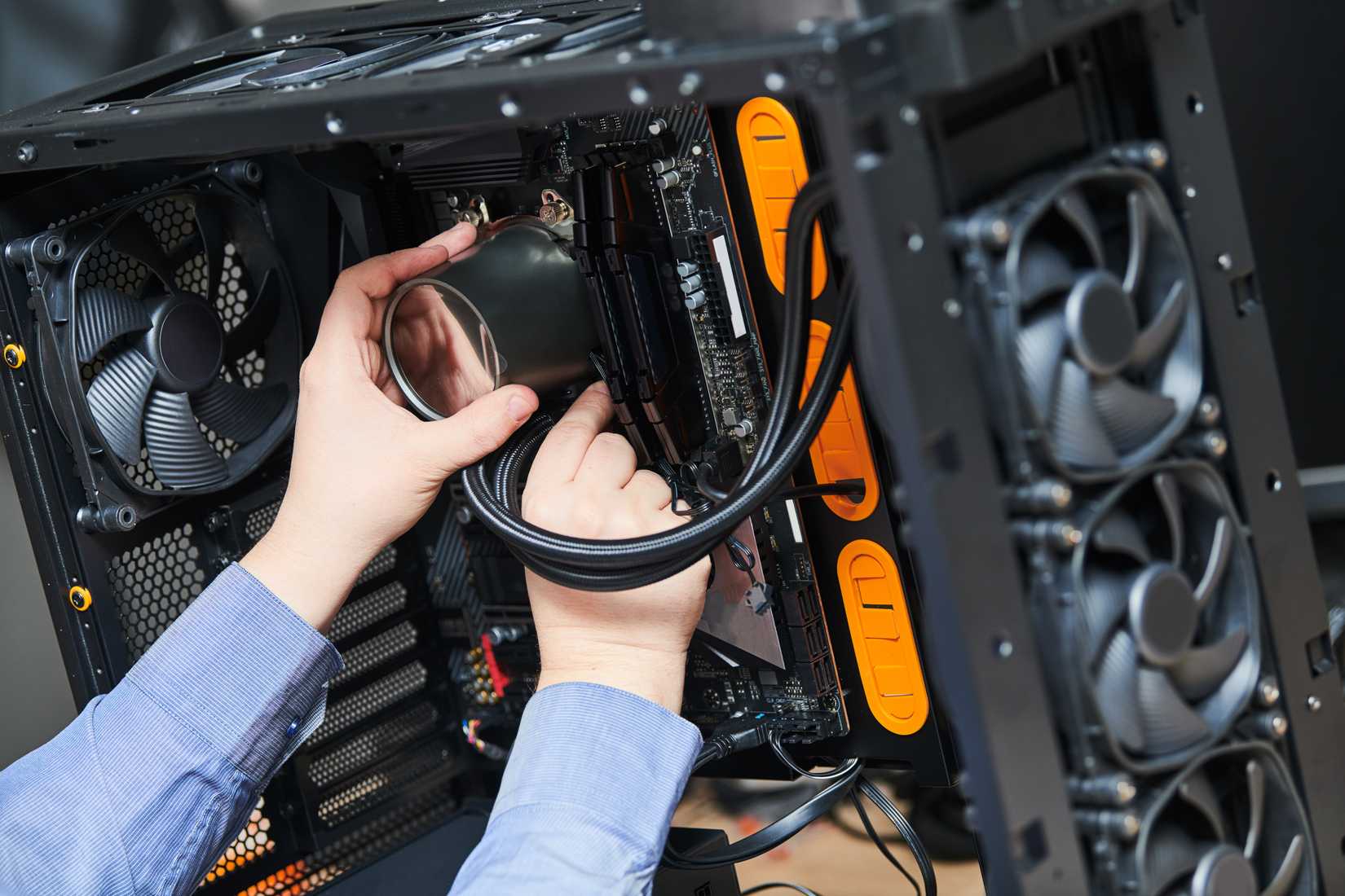 A person installs a large water cooler in a PC.