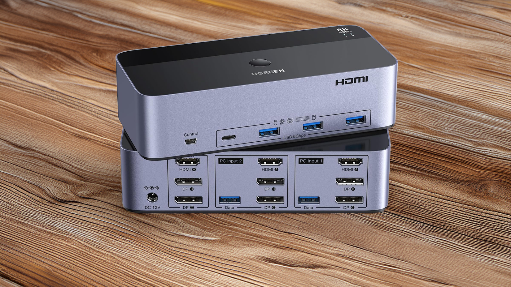 A UGREEN KVM Switch sitting on a wooden table.