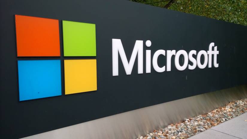 Microsoft logo featuring four colored squares next to white text on a dark sign.