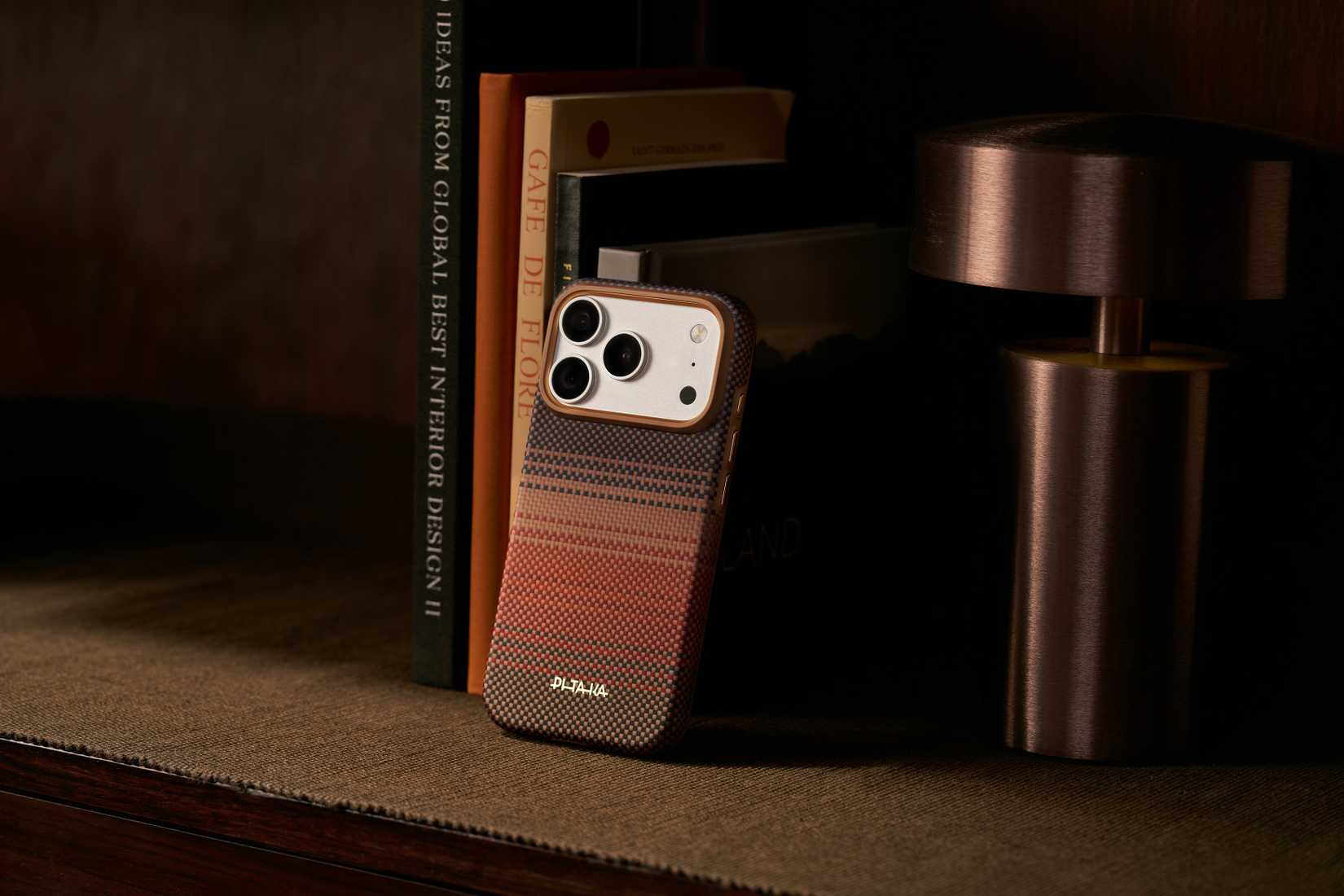 The PITAKA Summa case leaning against books on a bookcase