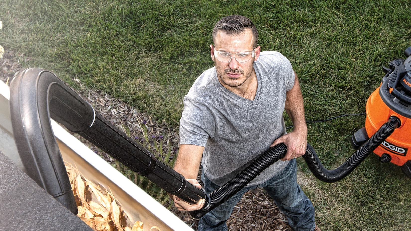 photo of a man using the Ridgid wet/dry vac gutter cleaning accessory set