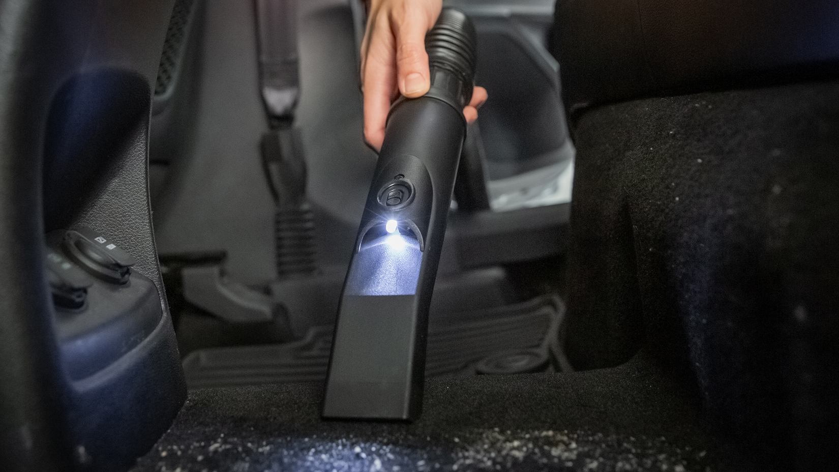Photo of a Ridgid LED vacuum attachment for auto detailing, showing it in action on the vehicle's floor