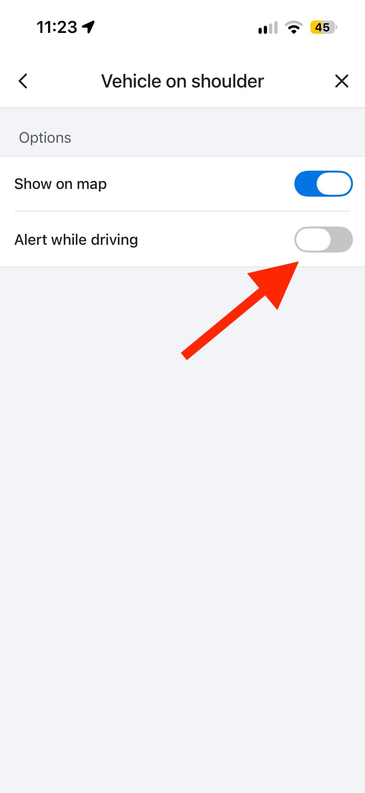 Waze Vehicle on shoulder alert settings page with arrow pointing to the Alert while driving toggle.