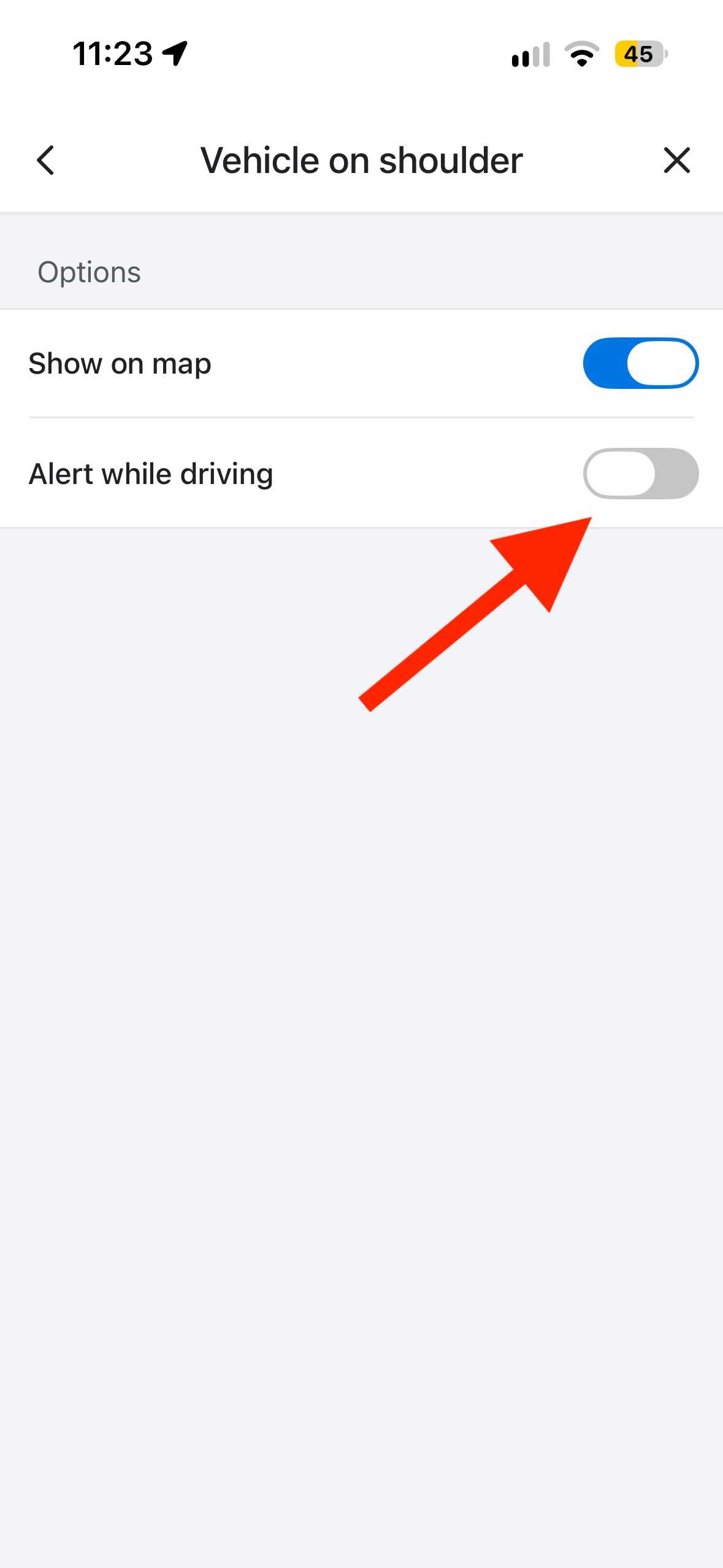Waze Vehicle on shoulder alert settings page with arrow pointing to the Alert while driving toggle.