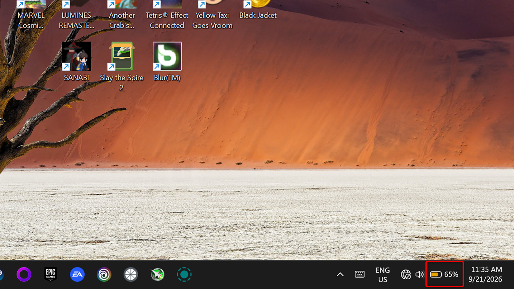 Windows 11 system tray with the battery icon turned orange, indicating that energy saver is enabled.