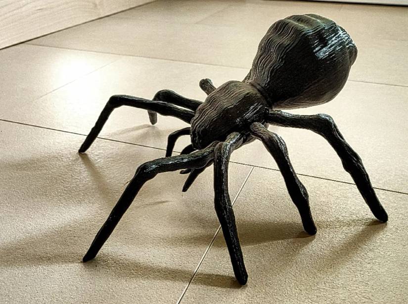 A large 3D-printed spider model with posable body and legs.