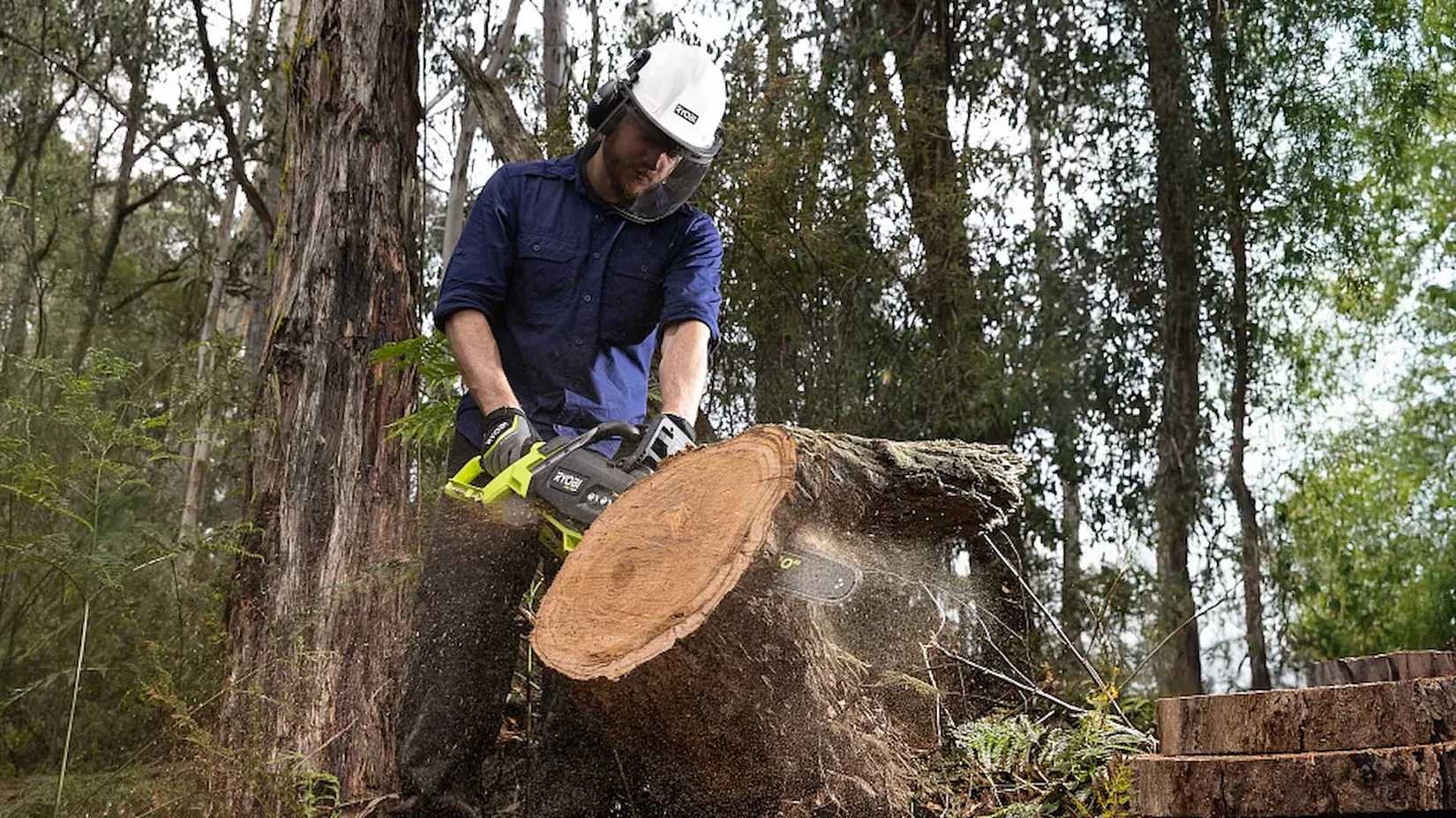 36V HP Brushless 20 Chainsaw being used to cut a tree trunk into pieces
