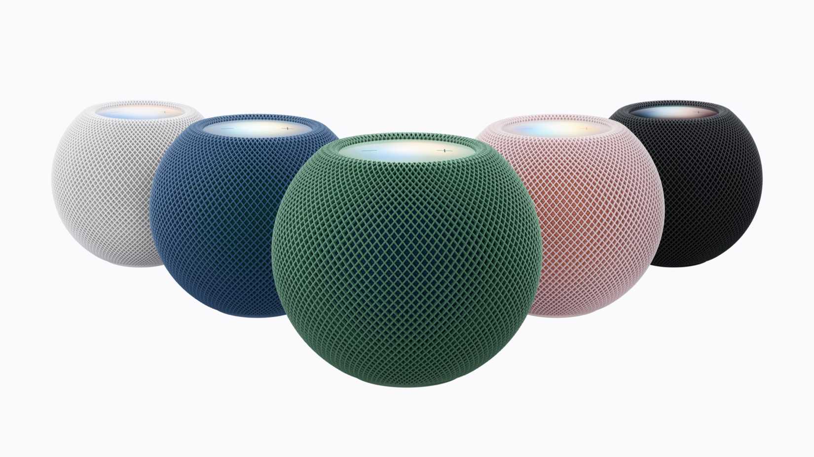 Five Apple HomePod mini speakers in white, blue, green, pink, and midnight black, showcasing their spherical design and mesh fabric exterior.