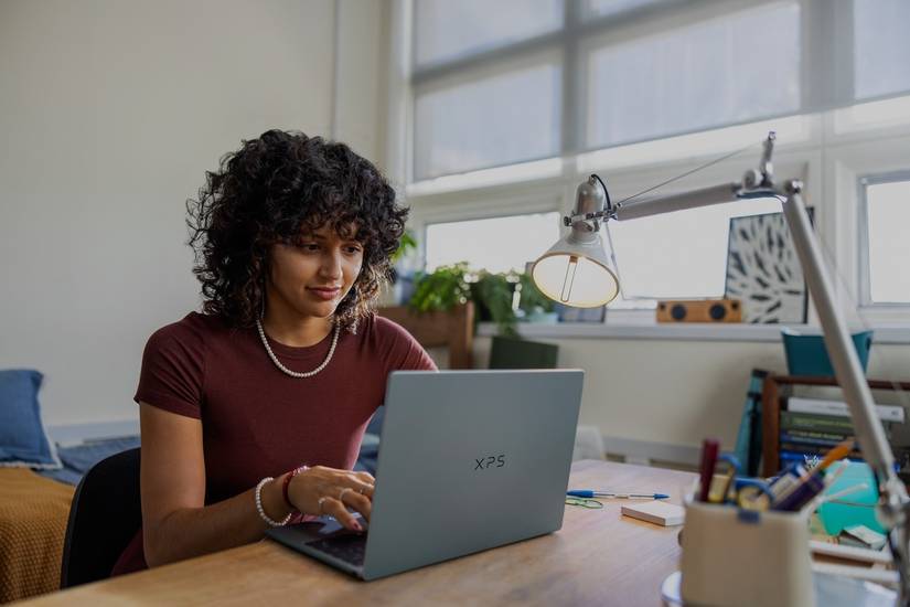 Woman typing on the Dell XPS 13 in her dorm room.