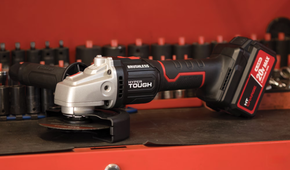 The Hyper Tough cordless angle grinder sitting on a workbench with sockets behind it.