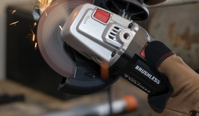 A person using the Hyper Tough angle grinder to cut a pipe.