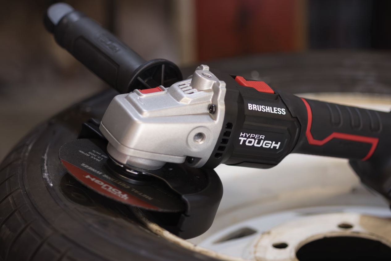 The cordless Hyper Tough angle grinder sitting on a tire.
