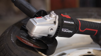 The cordless Hyper Tough angle grinder sitting on a tire.