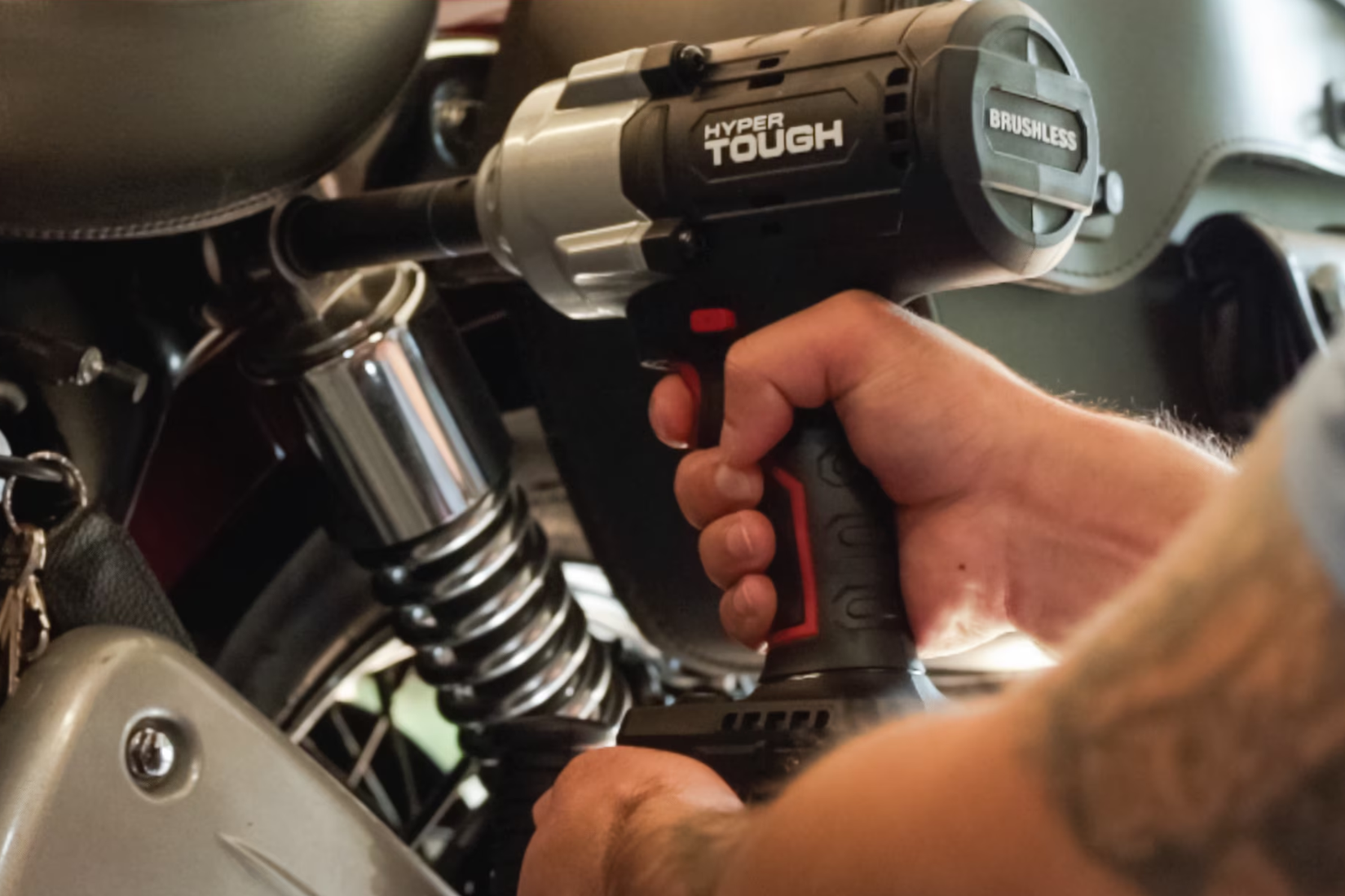 Hyper Tough's high-torque impact driver being used to tighten a bolt on an engine.