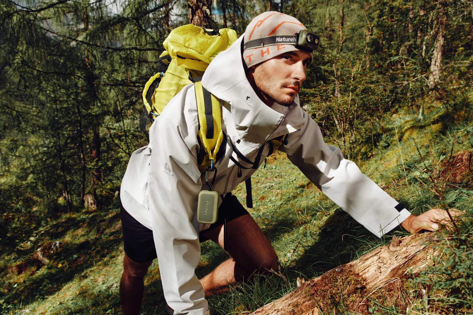 Man wearing an INIU Rugged Series power bank in the woods.