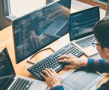 Person coding on multiple devices