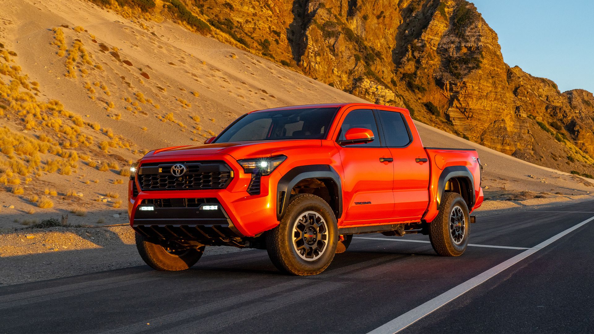 Static front 3/4 shot of an orange 2025 Toyota Tacoma TRD.