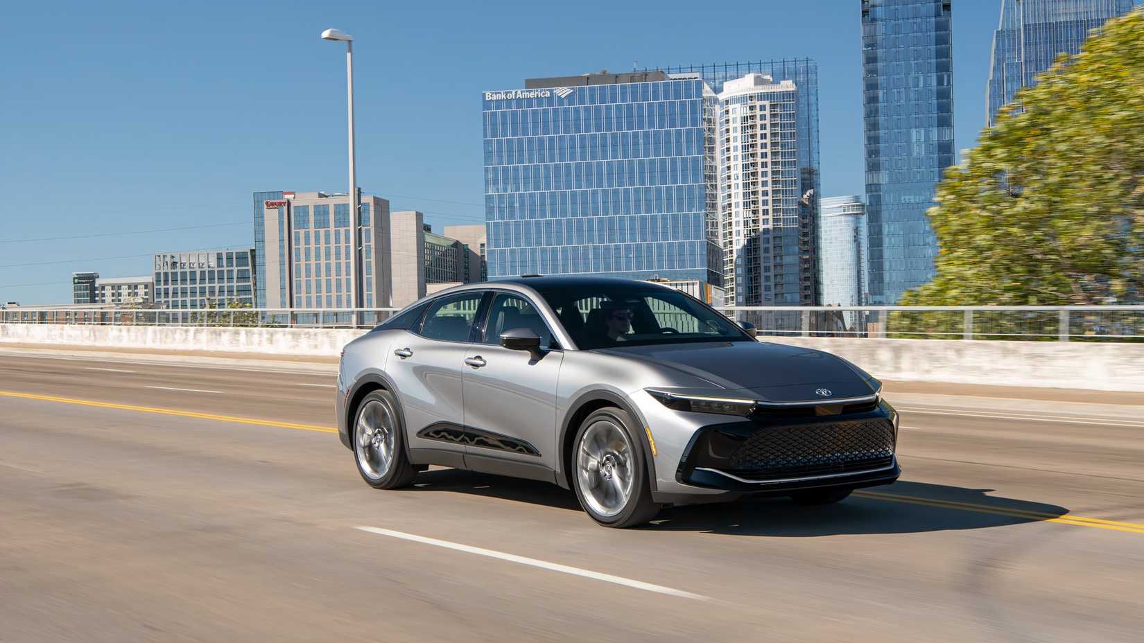 Toma dinámica de 3/4 del frente de un Toyota Crown gris 2026.