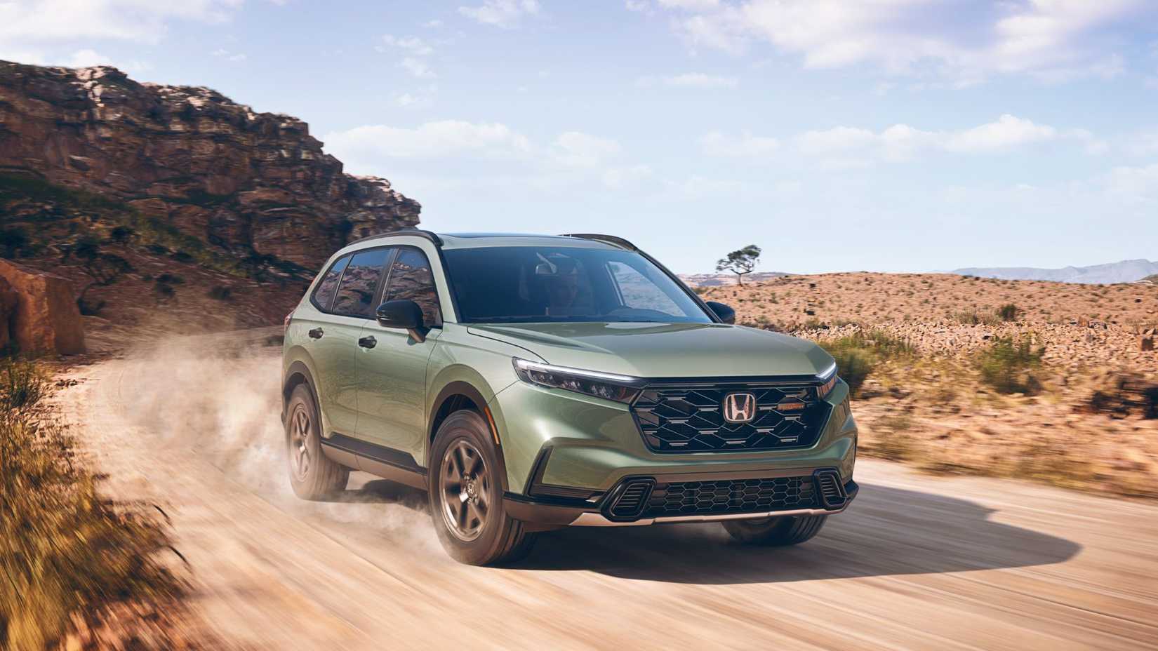 Dynamic front 3/4 shot of a green 2026 Honda CR-V Trailsport Hybrid.
