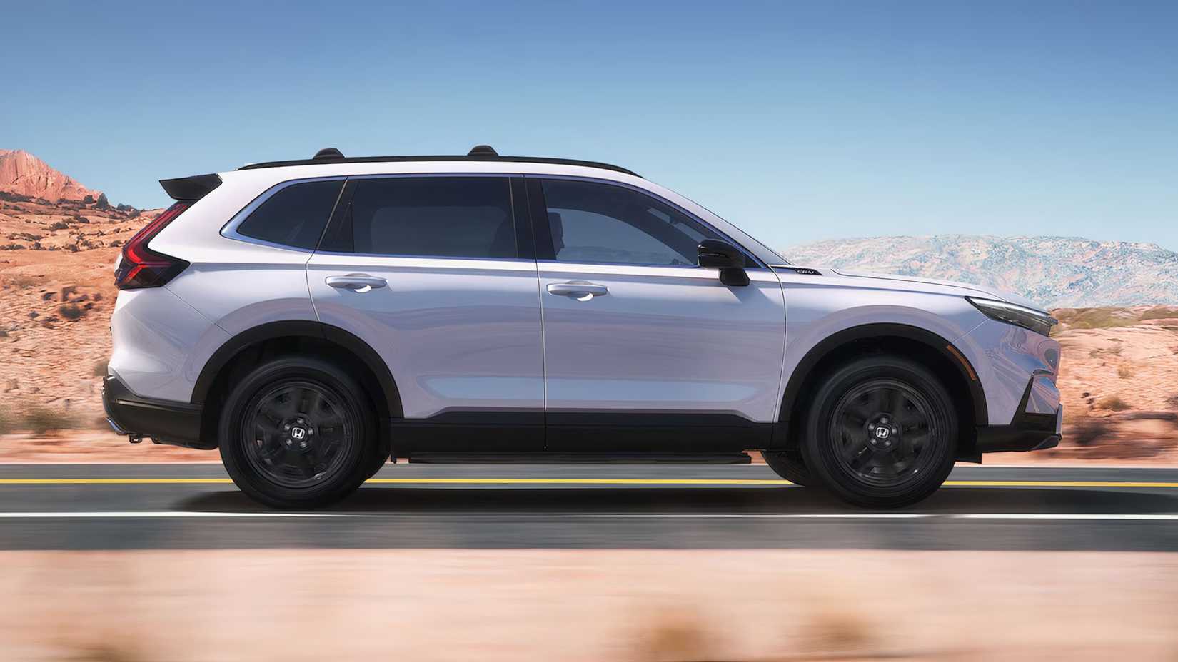 Dynamic side profile shot of a white 2025 Honda CR-V Hybrid.