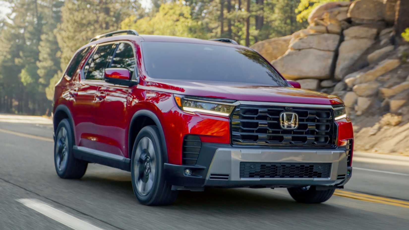 Dynamic front 3/4 shot of a red 2026 Honda Pilot Elite.