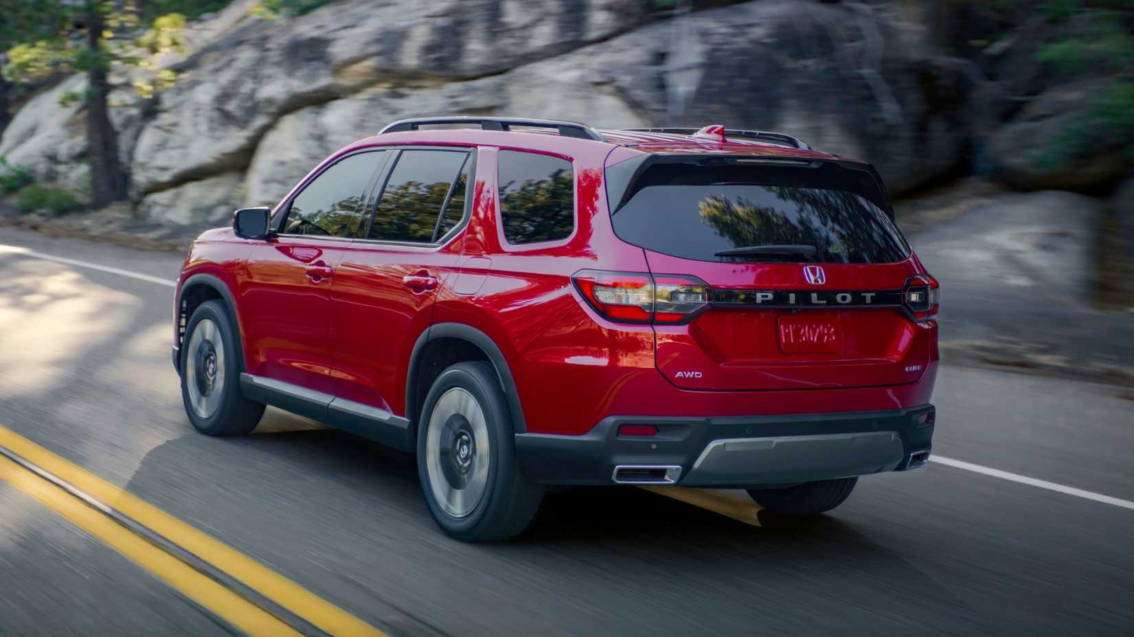 Dynamic rear 3/4 shot of a red 2026 Honda Pilot Elite.
