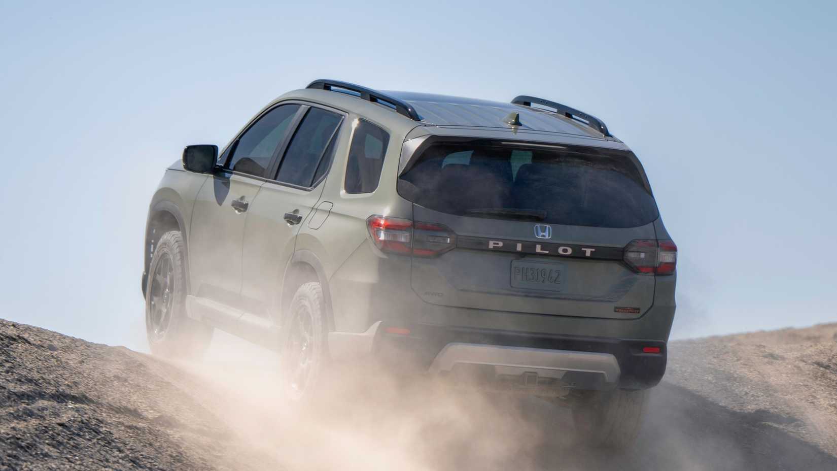 Dynamic rear 3/4 shot of a green 2026 Honda Pilot TrailSport.