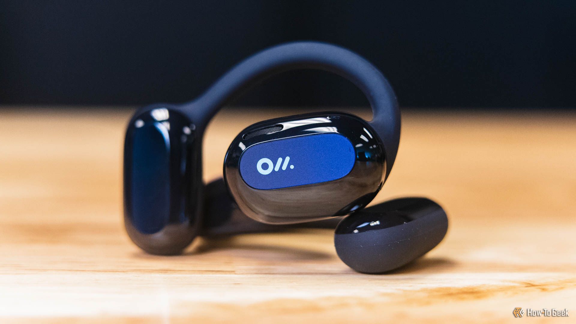 The Oladance Open-Ear Headphones on a wooden table.