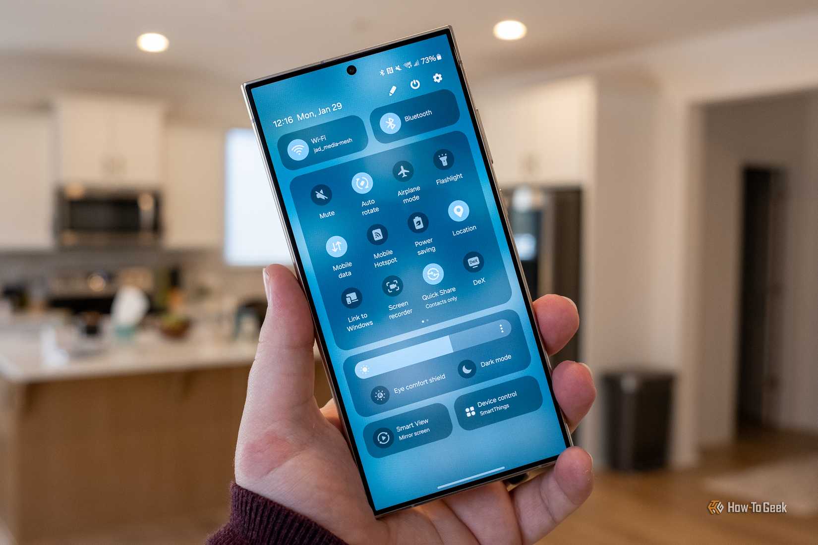 Person holding Samsung Galaxy S24 Ultra showing quick settings menu