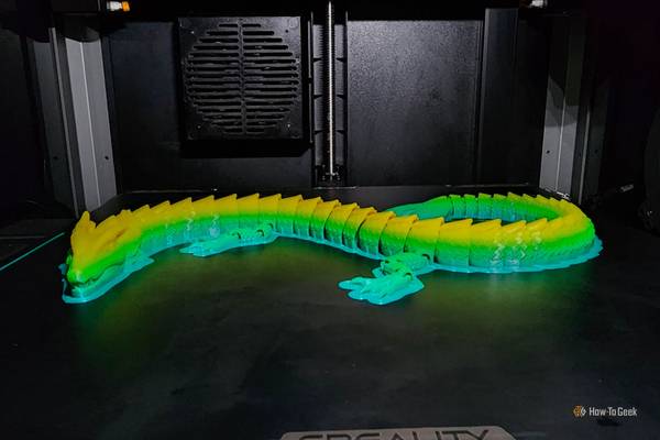 An image of a multi-colored 3D-printed dragon just after completion by the Creality K1 Max