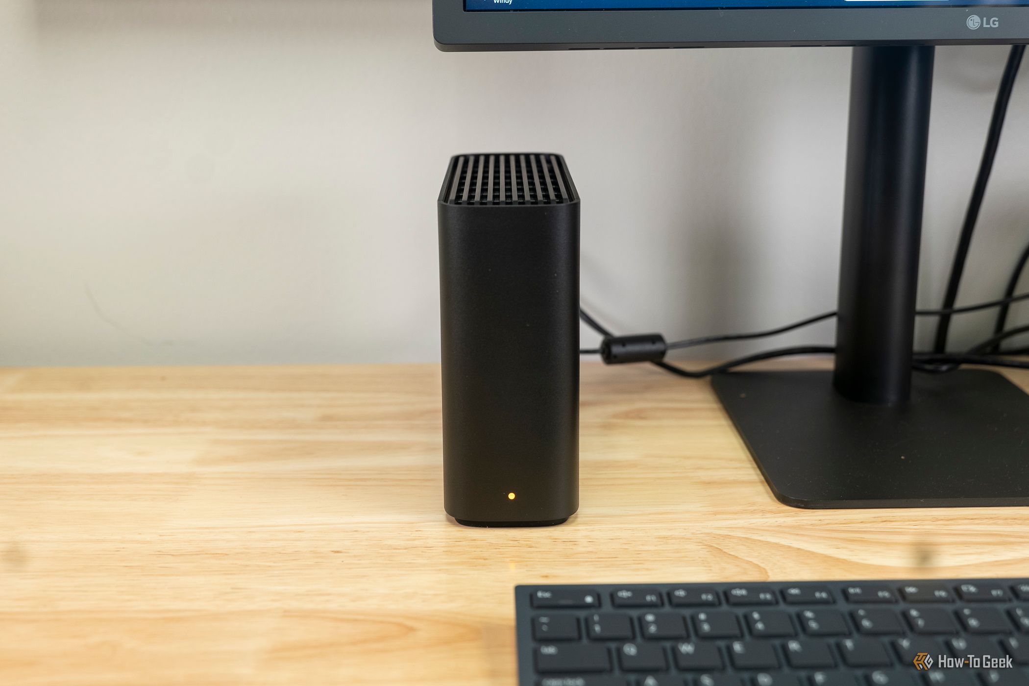 The Synology BeeStation next to a computer monitor.