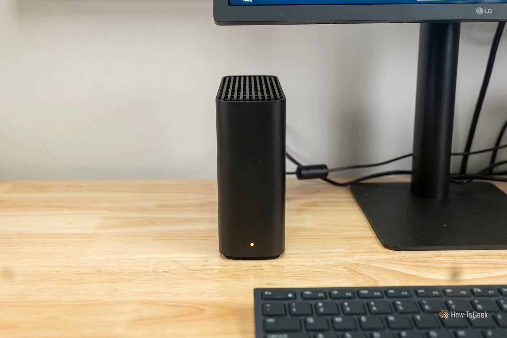 The Synology BeeStation next to a computer monitor.